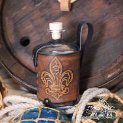 Big glass bottle with a Fleur-de-lys carved leather belt holder